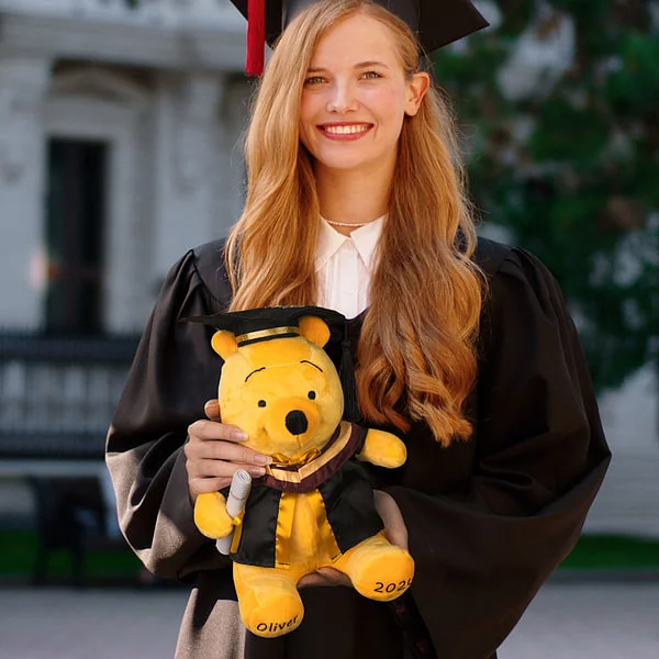 Diplômé tenant un ours à la main