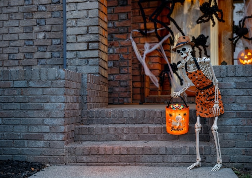 A poseable skeleton with a candy bucket